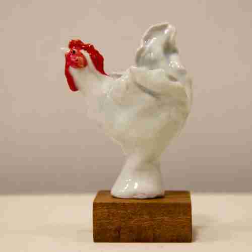 White porcelain hen sculpture on a hardwood base