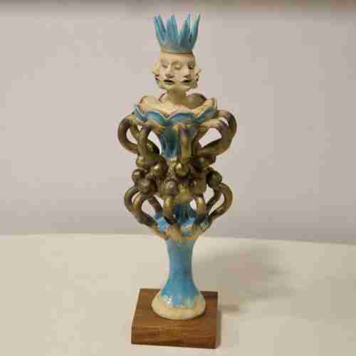 a multi faceted clay sculpture of a queen in turquoise glaze