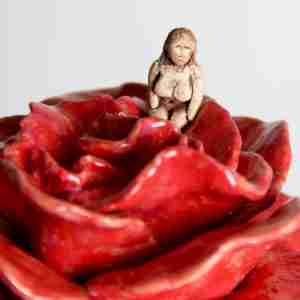 surreal sculpture with a rose and tiny Goddess