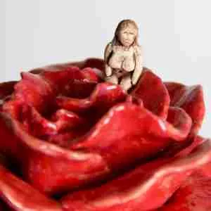 surreal sculpture with a rose and tiny Goddess