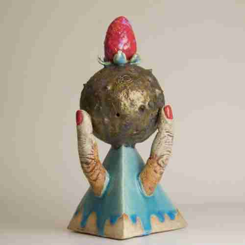 A surreal stoneware sculpture with a strawberry