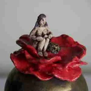 Surreal stoneware quirky sculpture with little tiny goddess sitting in a flower
