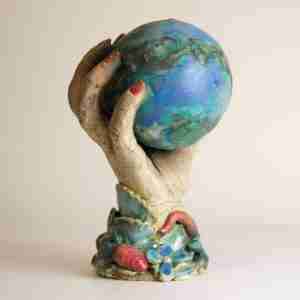Stoneware surreal sculpture with geometric shape, a hand and nature