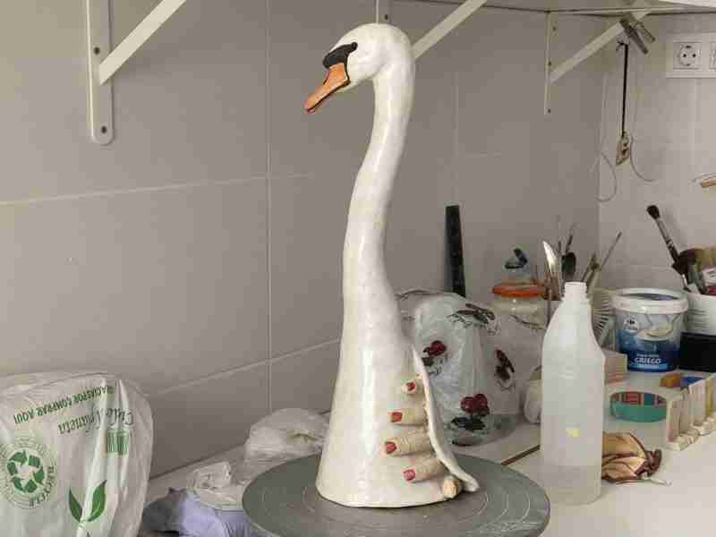 stoneware swan sculpture with human hand