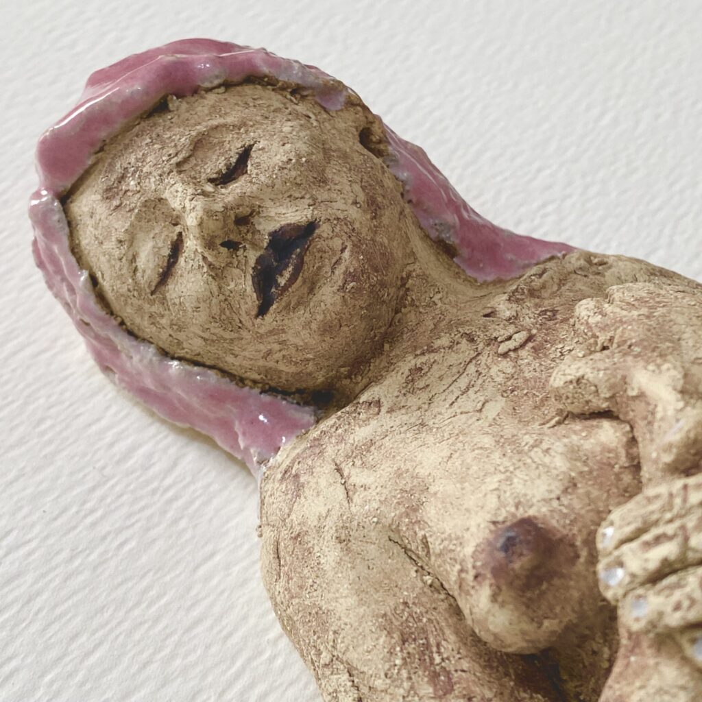 stoneware ceramic sculpture is a reclining nude with soft pink hair
