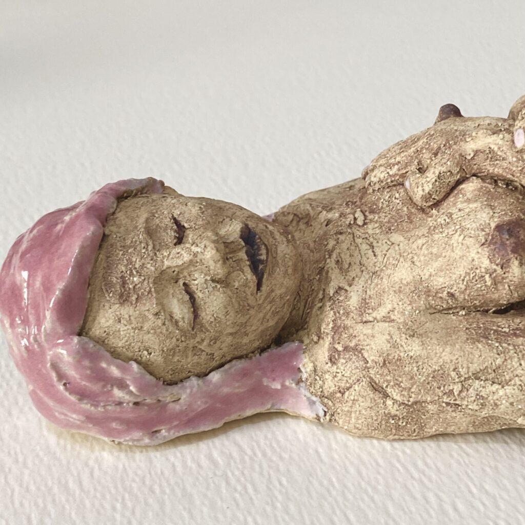 Stoneware ceramic sculpture of a reclining nude with pink hair